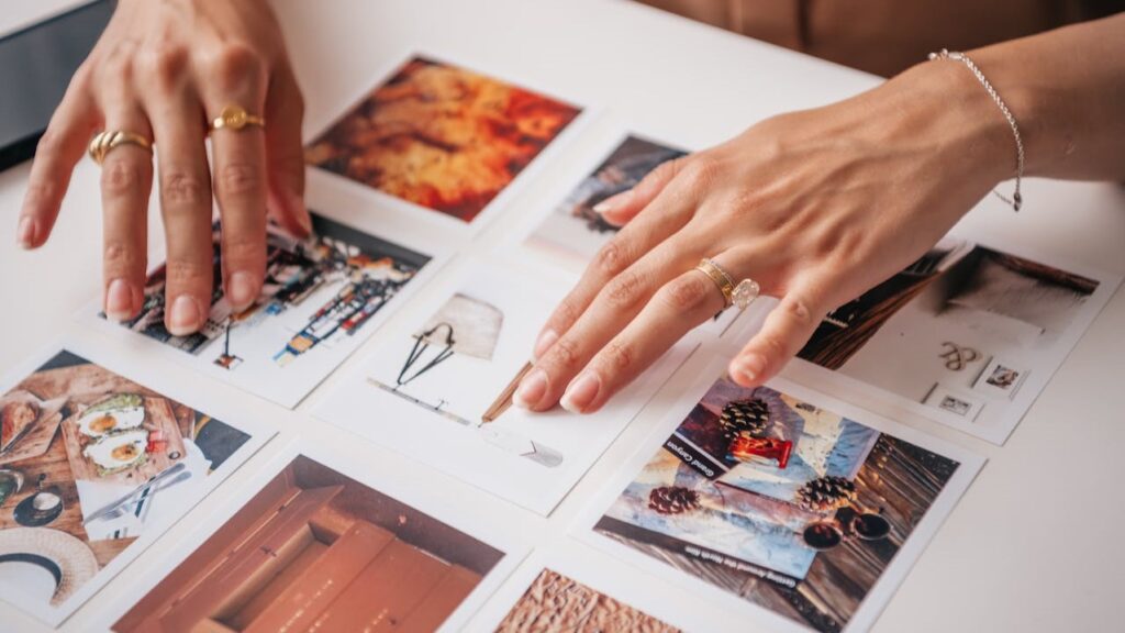 Twee handen rangschikken foto's voor een persoonlijk fotogeschenk met emotionele waarde