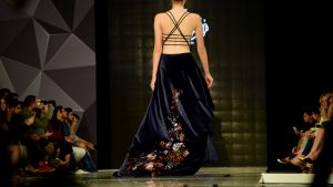 Model toont avondjurk op catwalk als eindresultaat van een fotoplan kledinglijn.