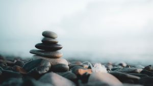 Gestapelde stenen op een kiezelstrand met zachte kleuren, die rust in je fotografie benadrukken