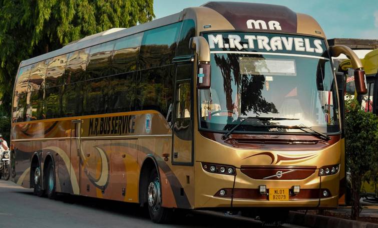 Luxe goudbruine touringcar van M.R. Travels klaar voor vertrek, ideaal onderwerp voor busspotten.